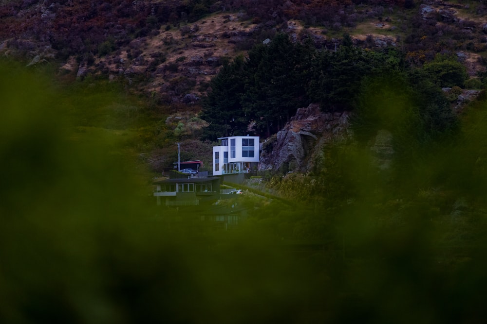 a white house sitting on top of a lush green hillside