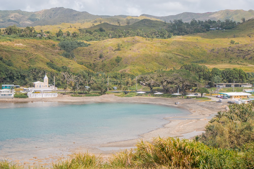 a body of water surrounded by lush green hills