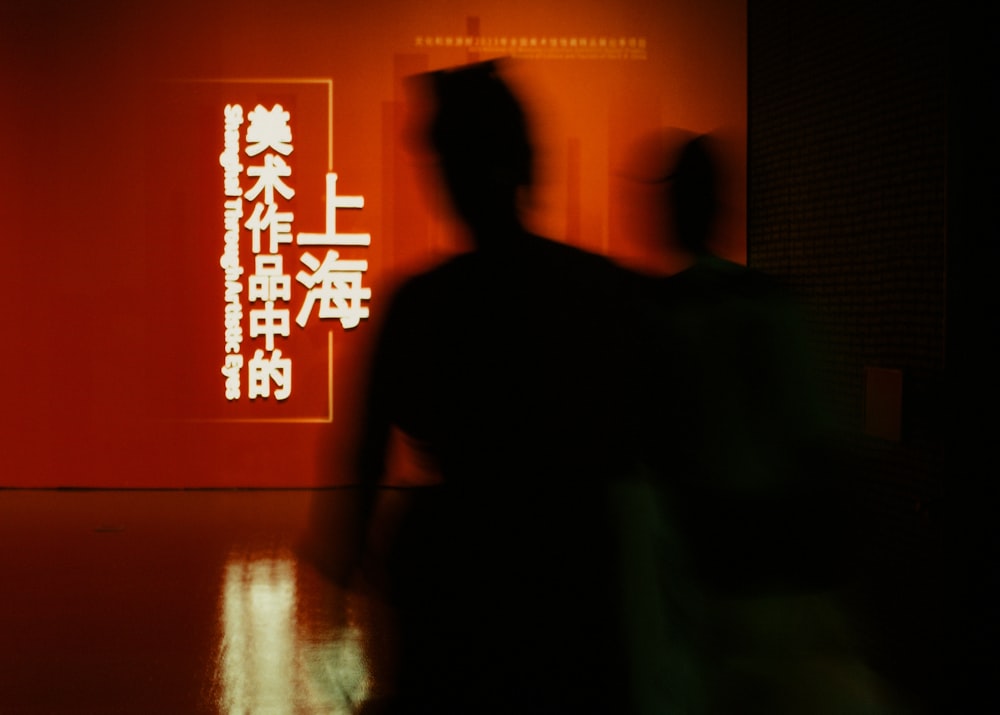 a man standing in front of a red wall