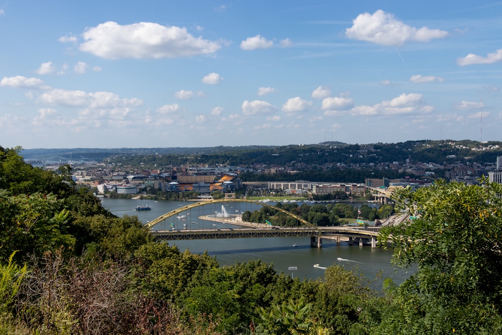 a bridge over a river with a city in the background