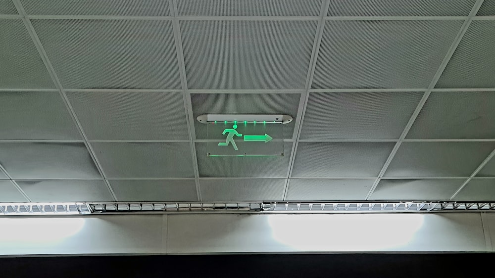 a green and white sign on the ceiling of a building