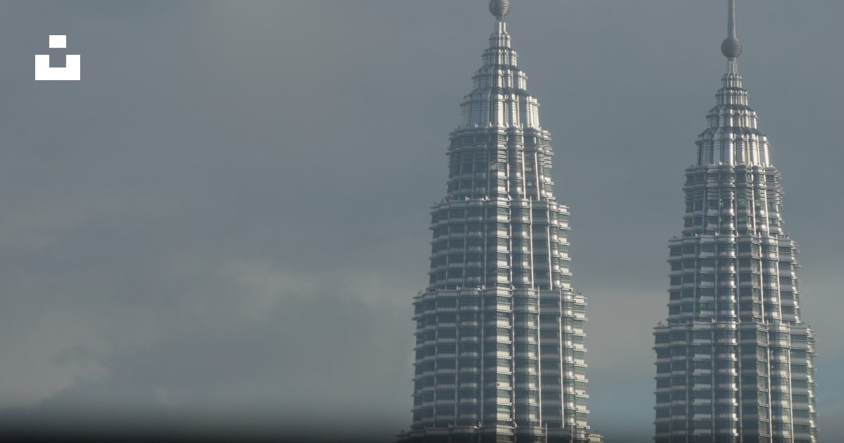 A couple of tall buildings sitting next to each other photo Free