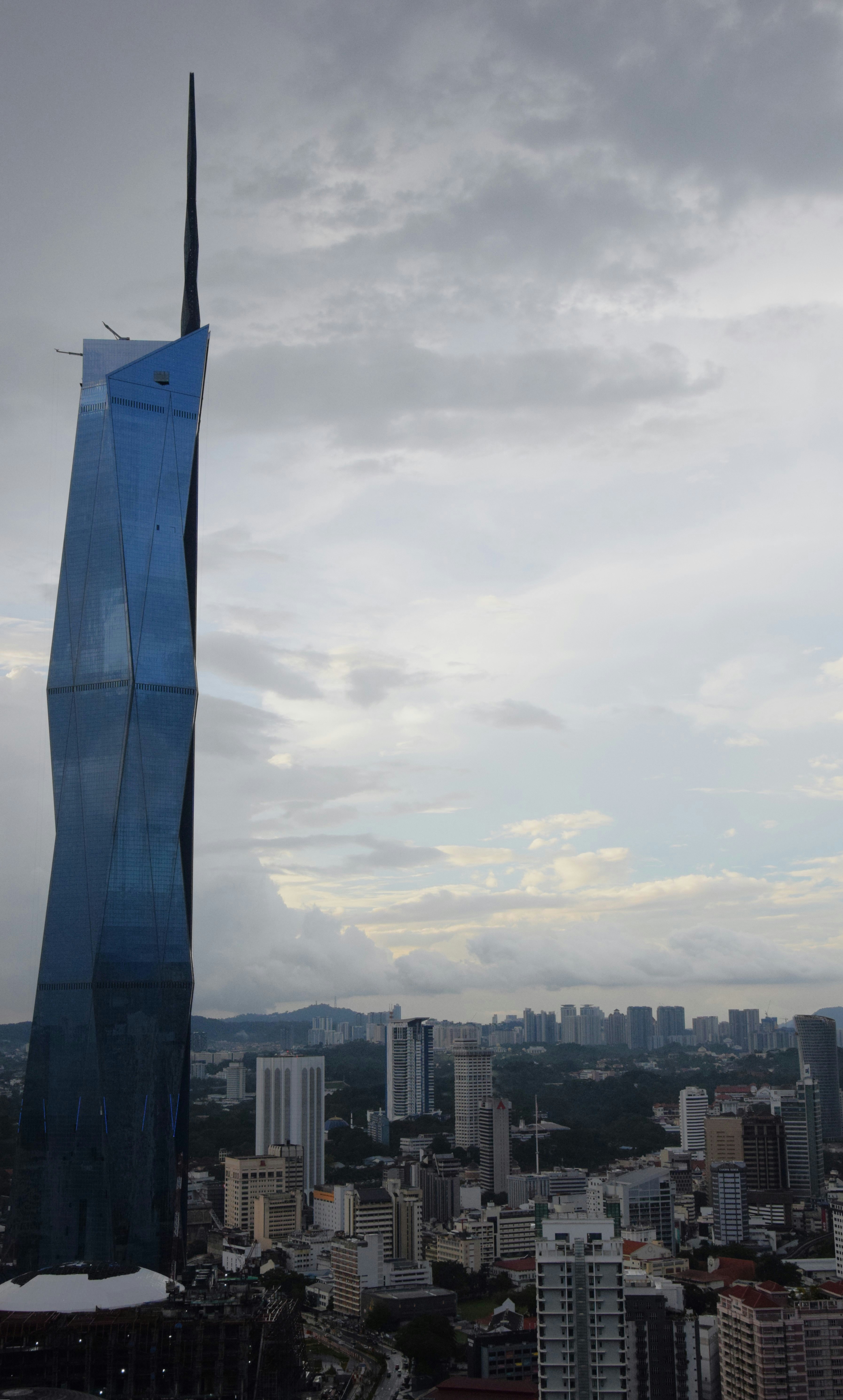 A very tall building towering over a city photo – Free Merdeka 118 ...