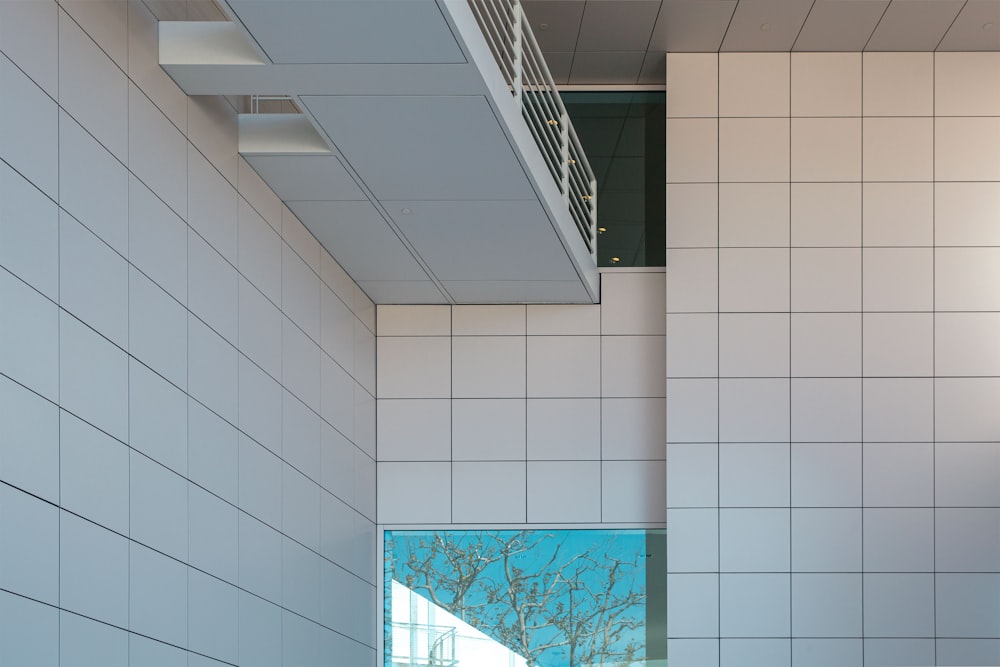 a bathroom with a white tiled wall next to a window