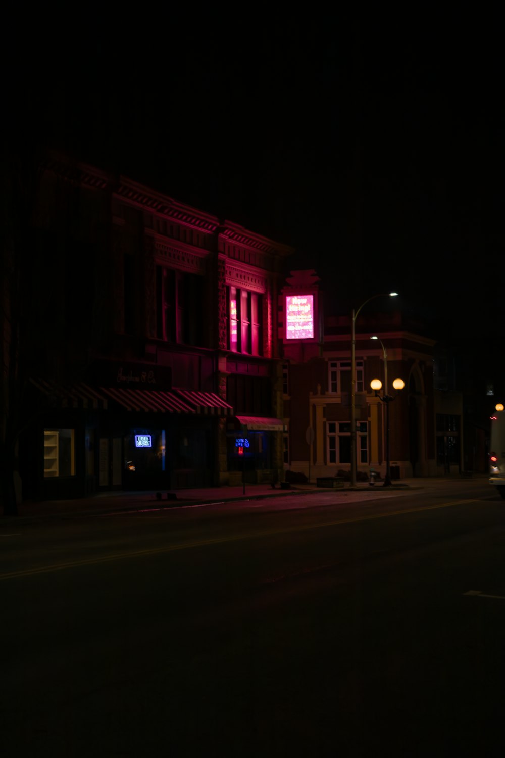 a street at night with a bus parked on the side of the road