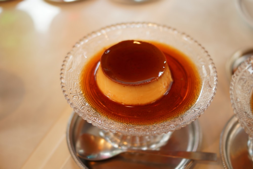 a small glass dish of caramel sauce on a table