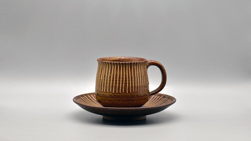 a brown cup and saucer sitting on a plate