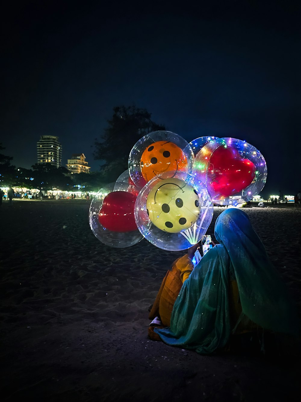 a person sitting on the ground with a bunch of balloons