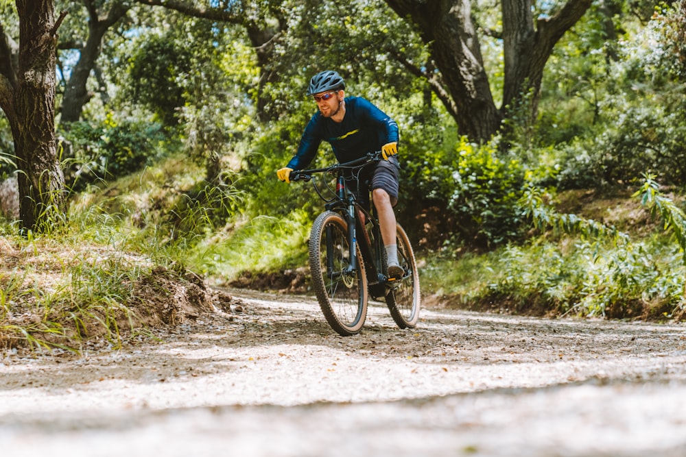 a man riding a bike down a dirt road