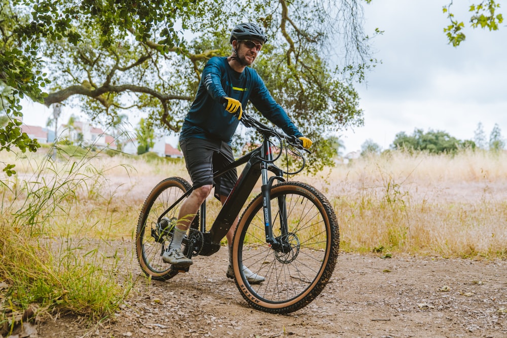 a man riding a bike down a dirt road