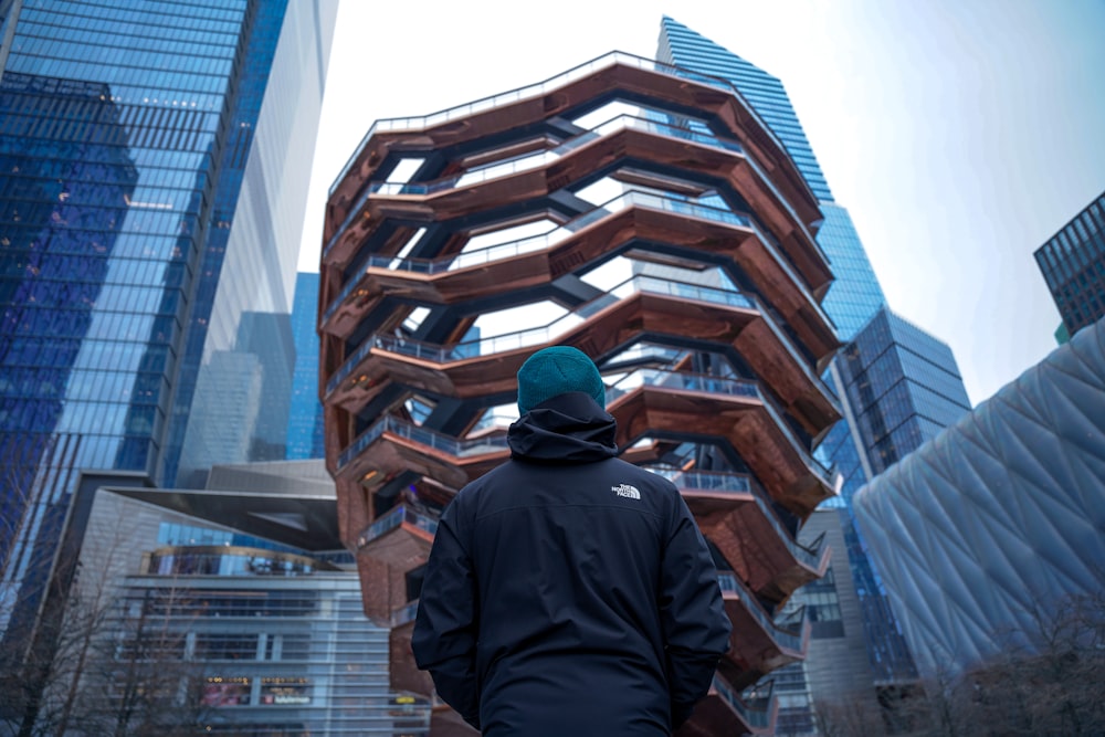 a man standing in front of a tall building