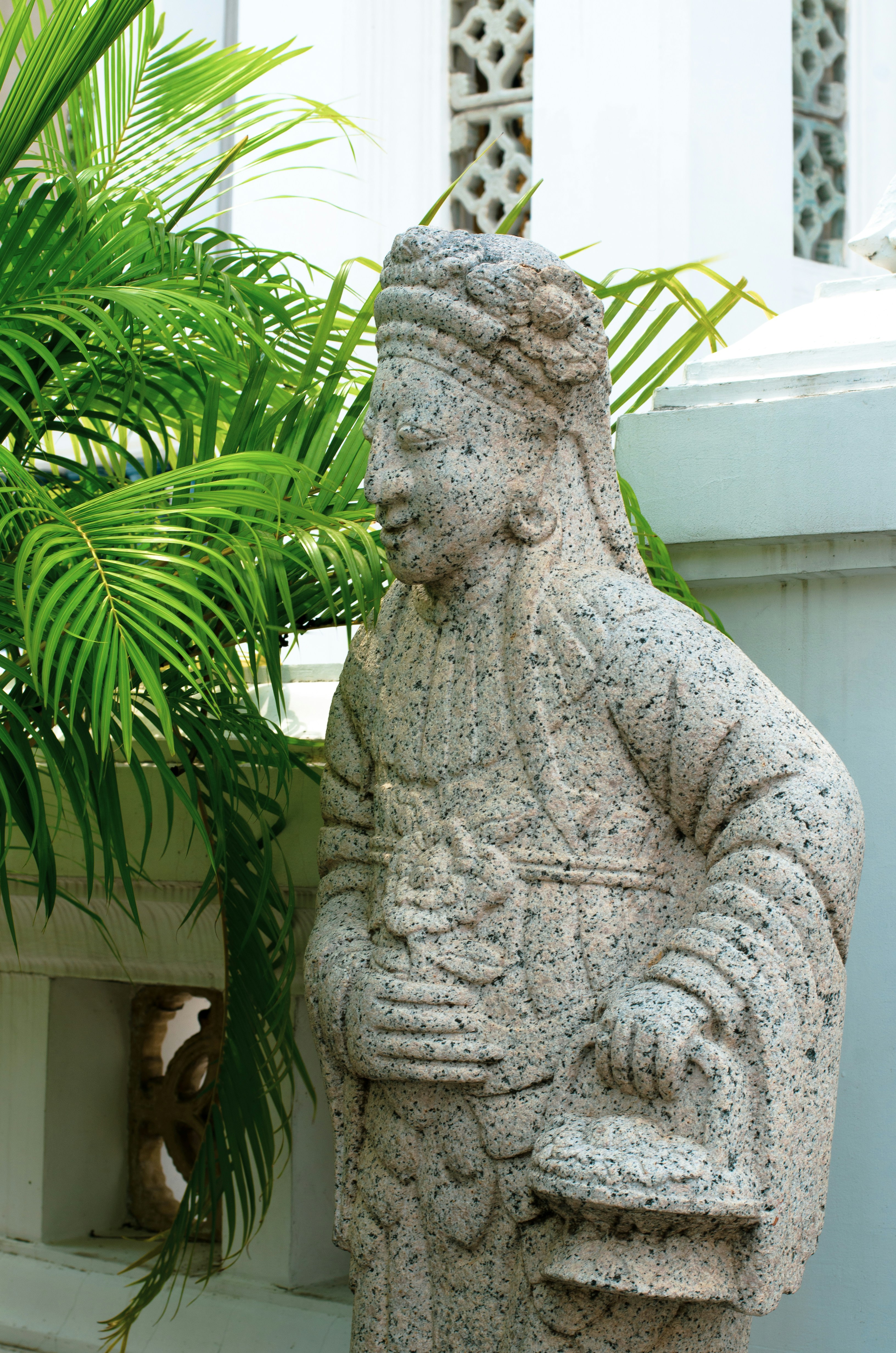 a statue of a man holding a potted plant