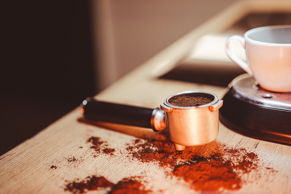 una tazza di caffè seduta sopra un tavolo di legno