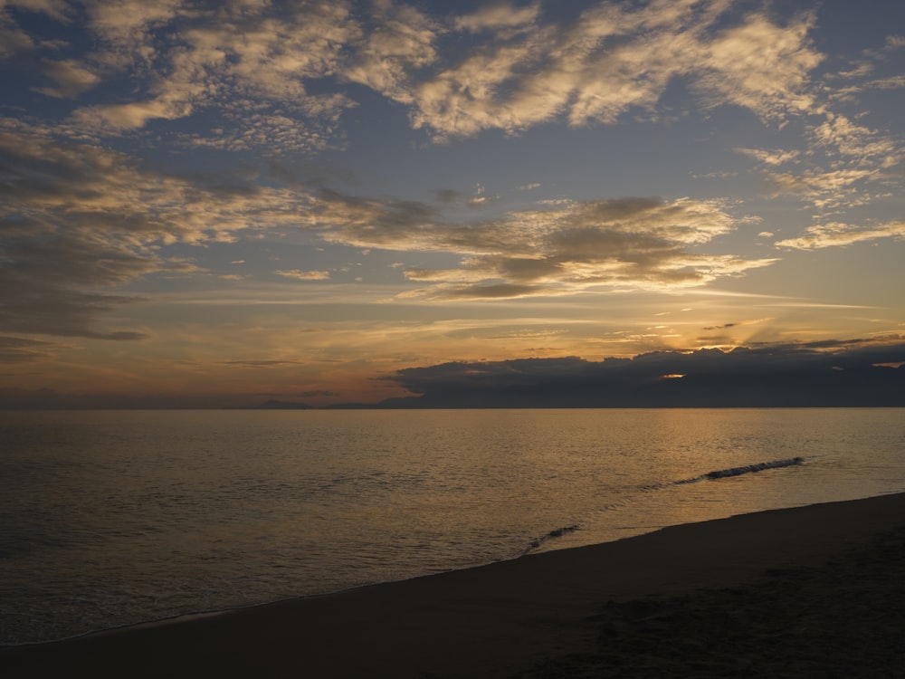 el sol se está poniendo sobre el océano en la playa