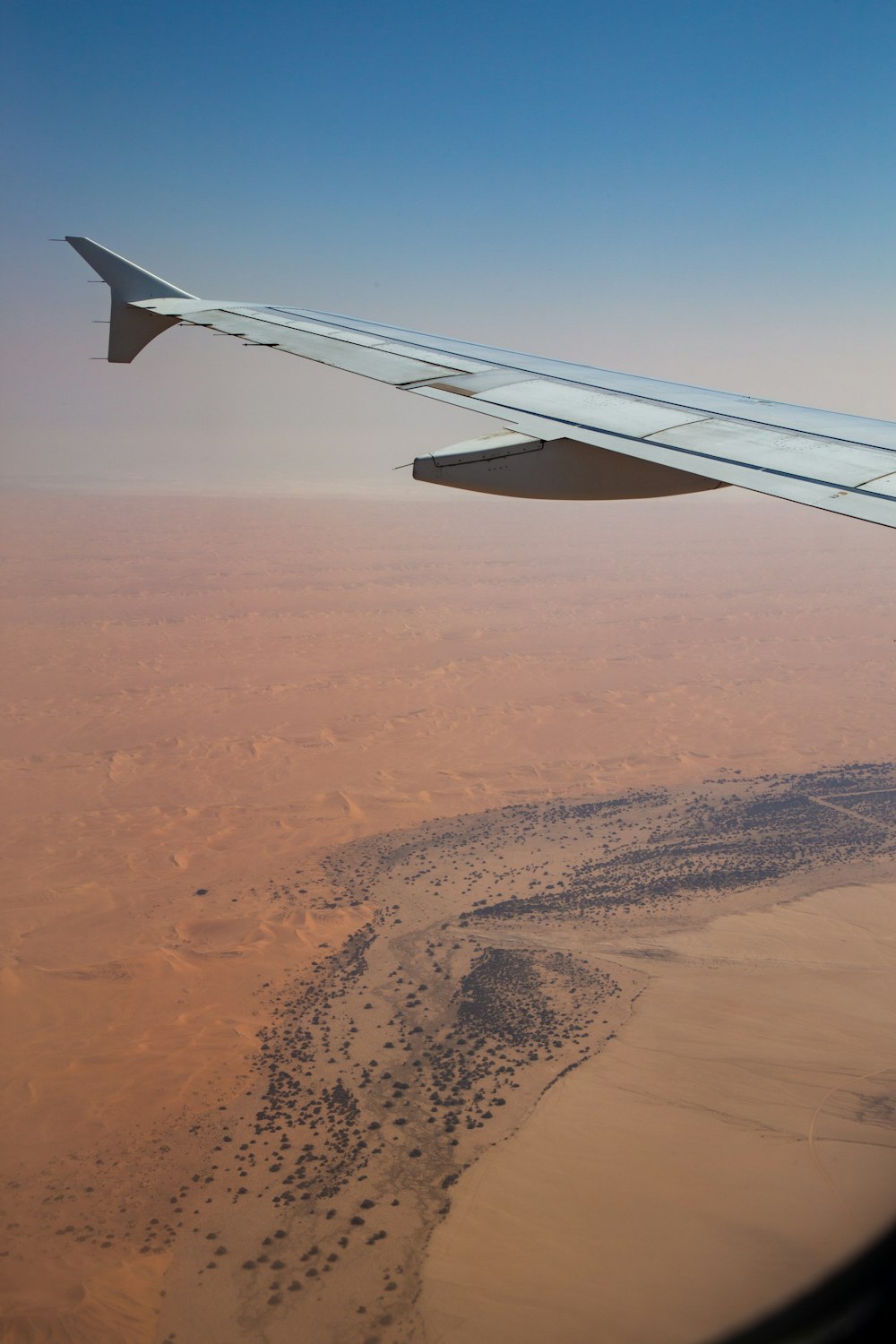 l'ala di un aeroplano che sorvola un deserto