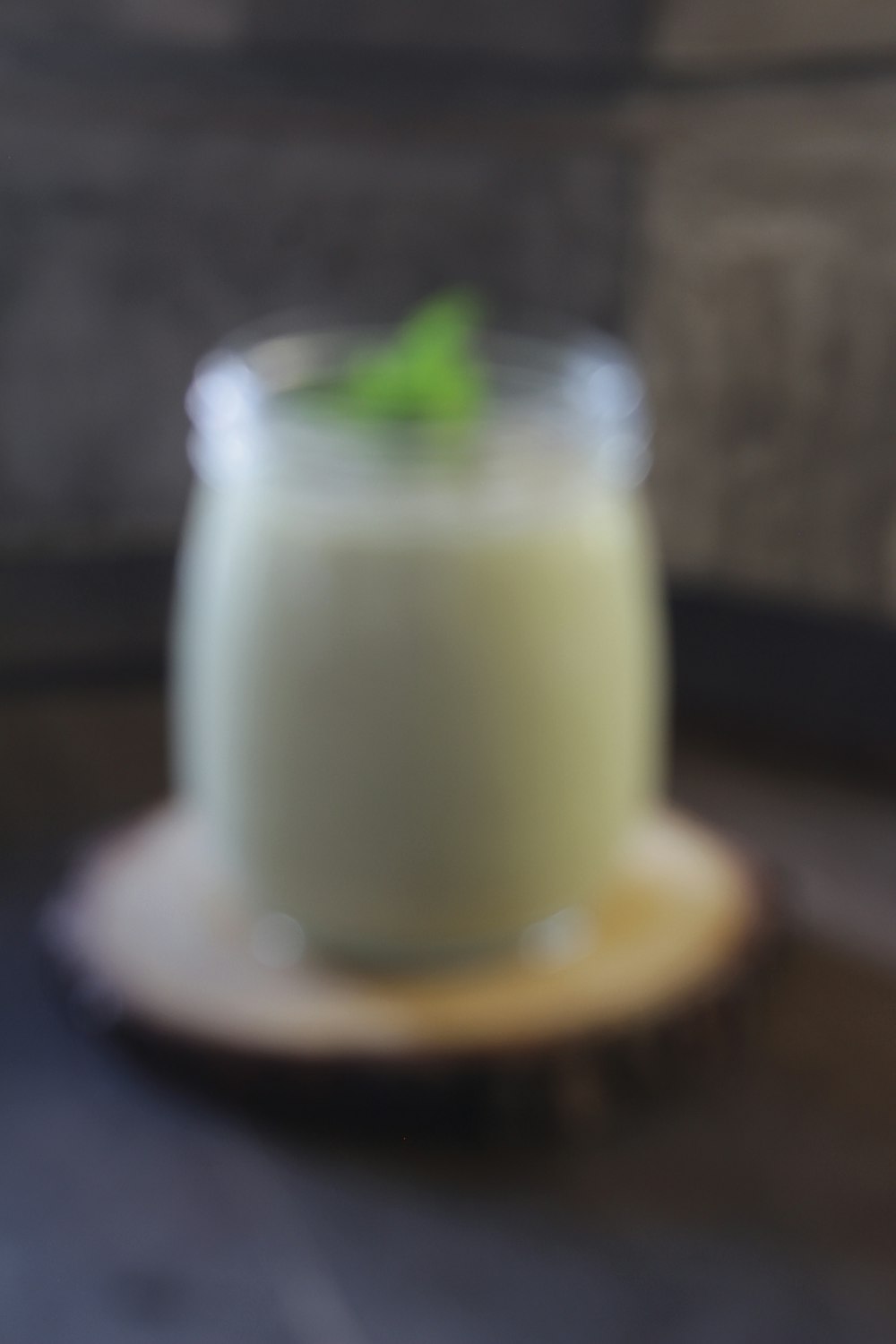 a glass of milk sitting on top of a wooden table