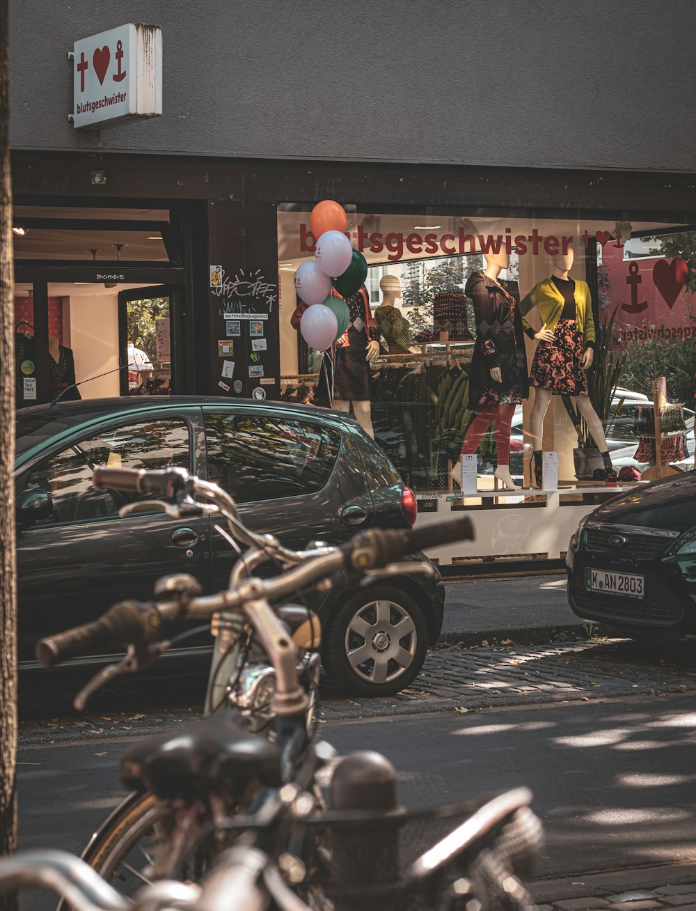 a couple of cars parked in front of a store