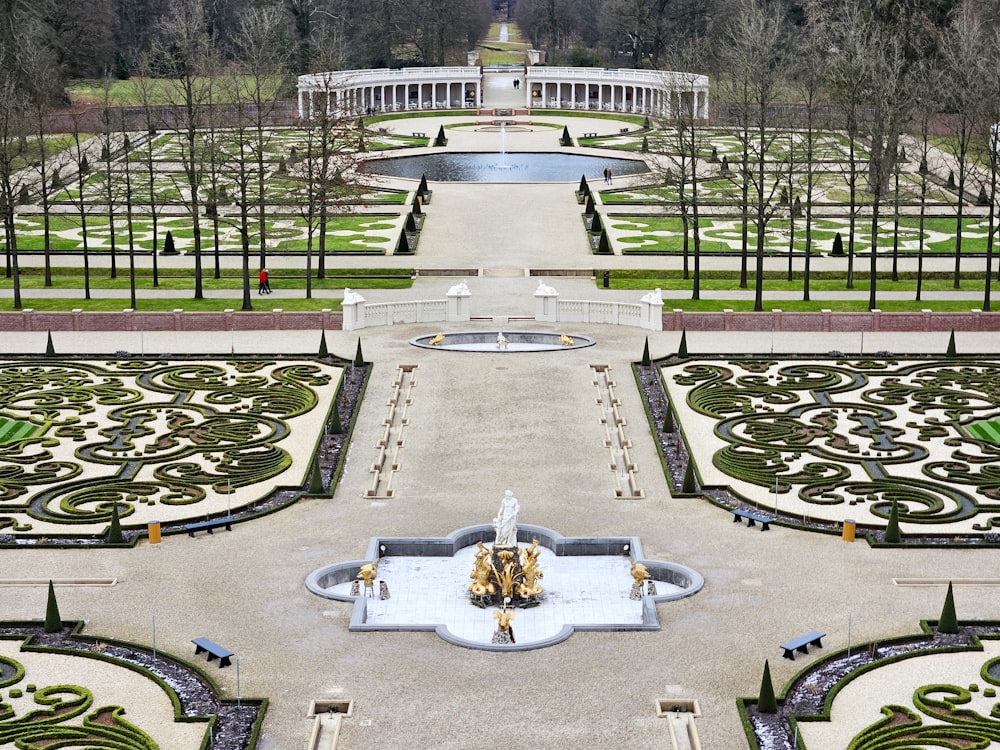 a large garden with a fountain in the middle of it