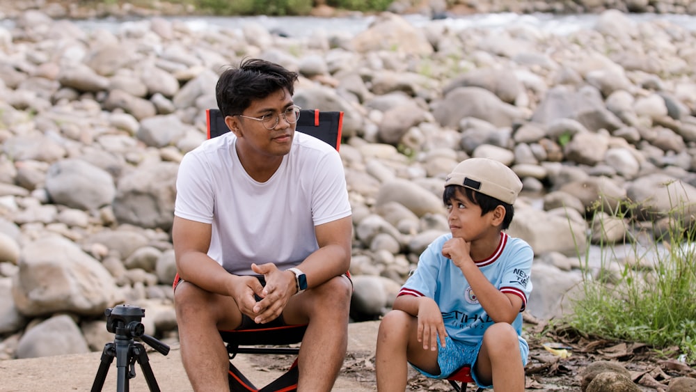 a man sitting next to a boy on a chair