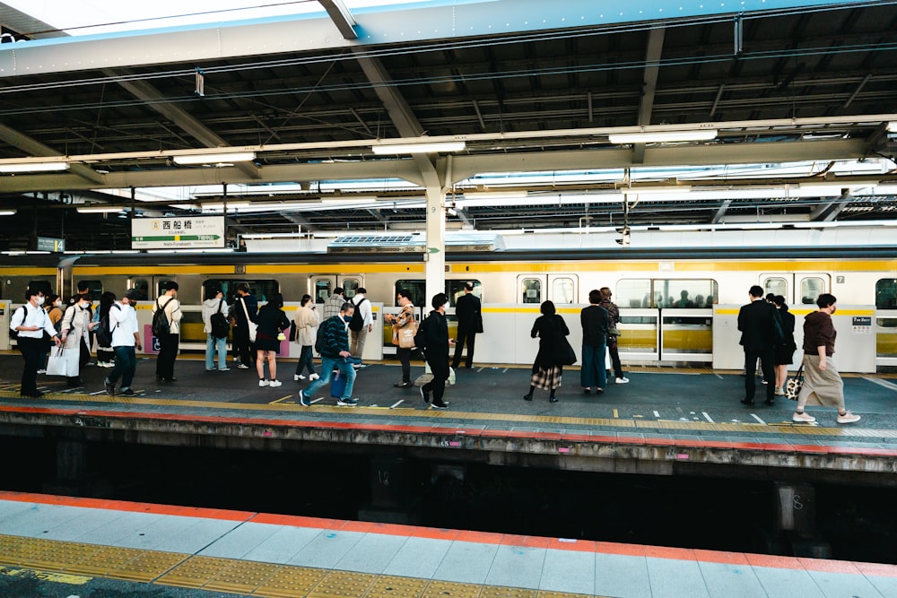 a group of people standing on a train platform