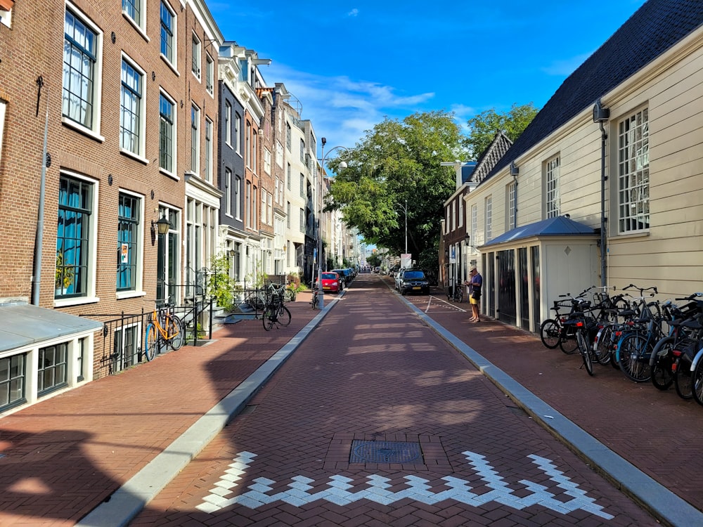 a street lined with parked bicycles next to tall buildings