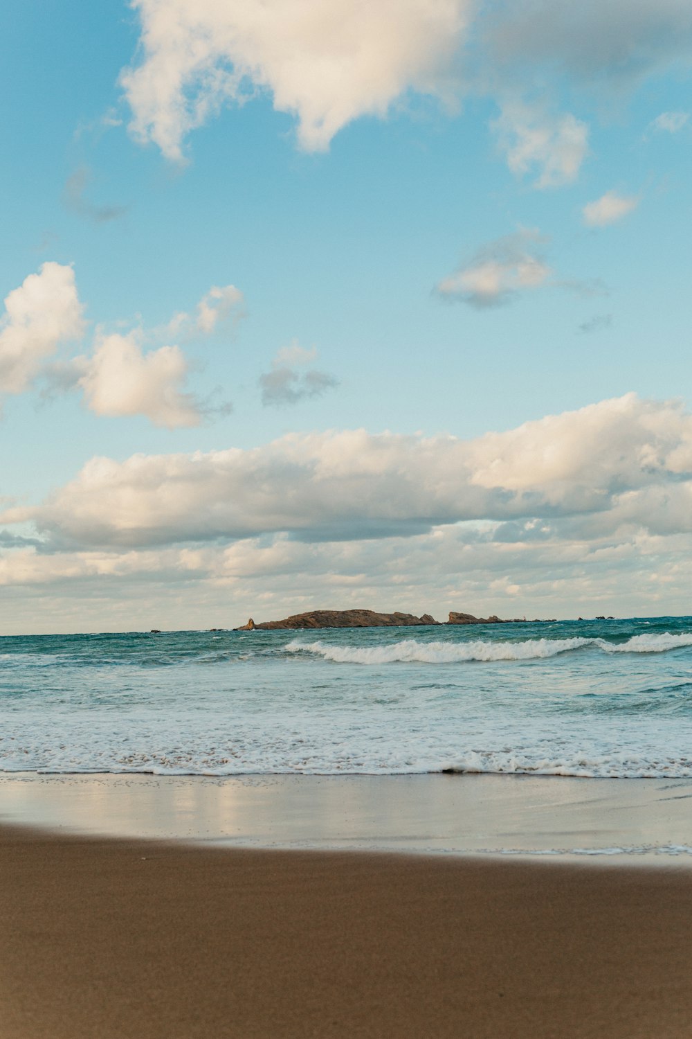 a person walking on the beach with a surfboard