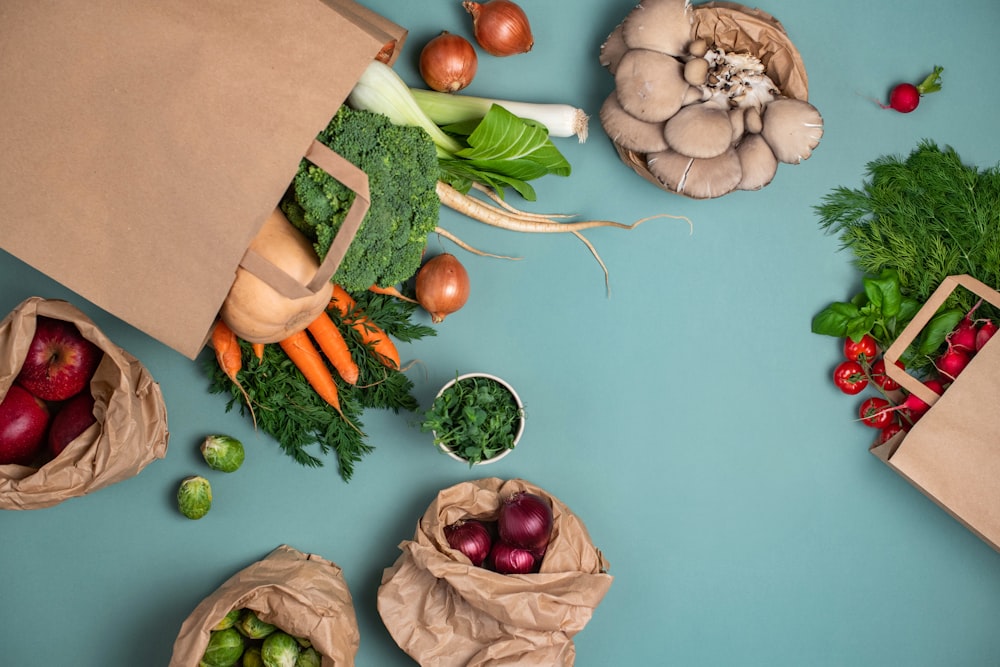 a table topped with bags filled with different types of vegetables