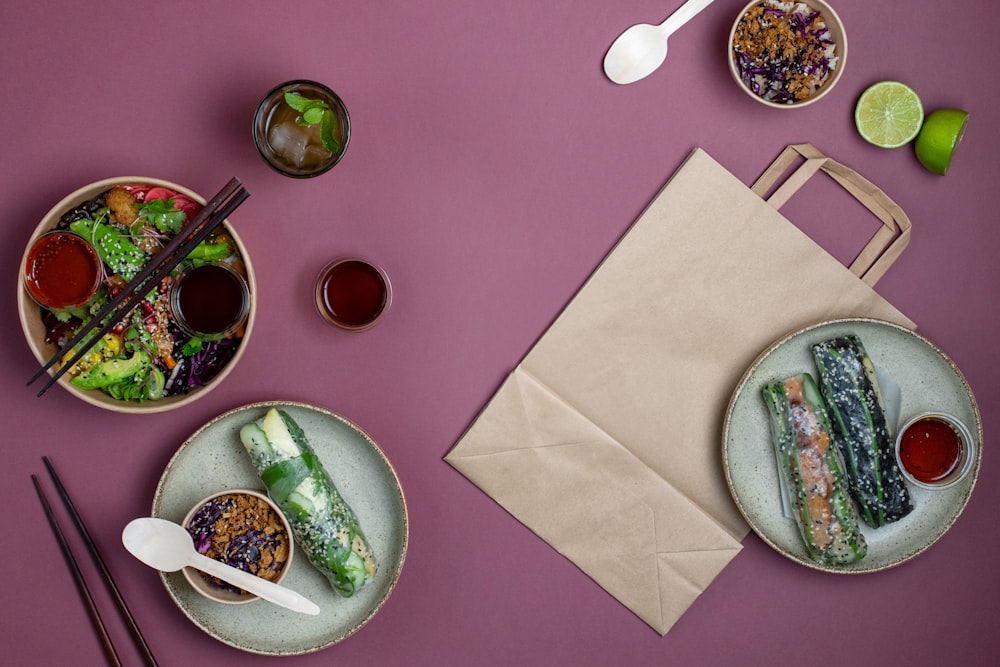 a table topped with plates of food and chopsticks