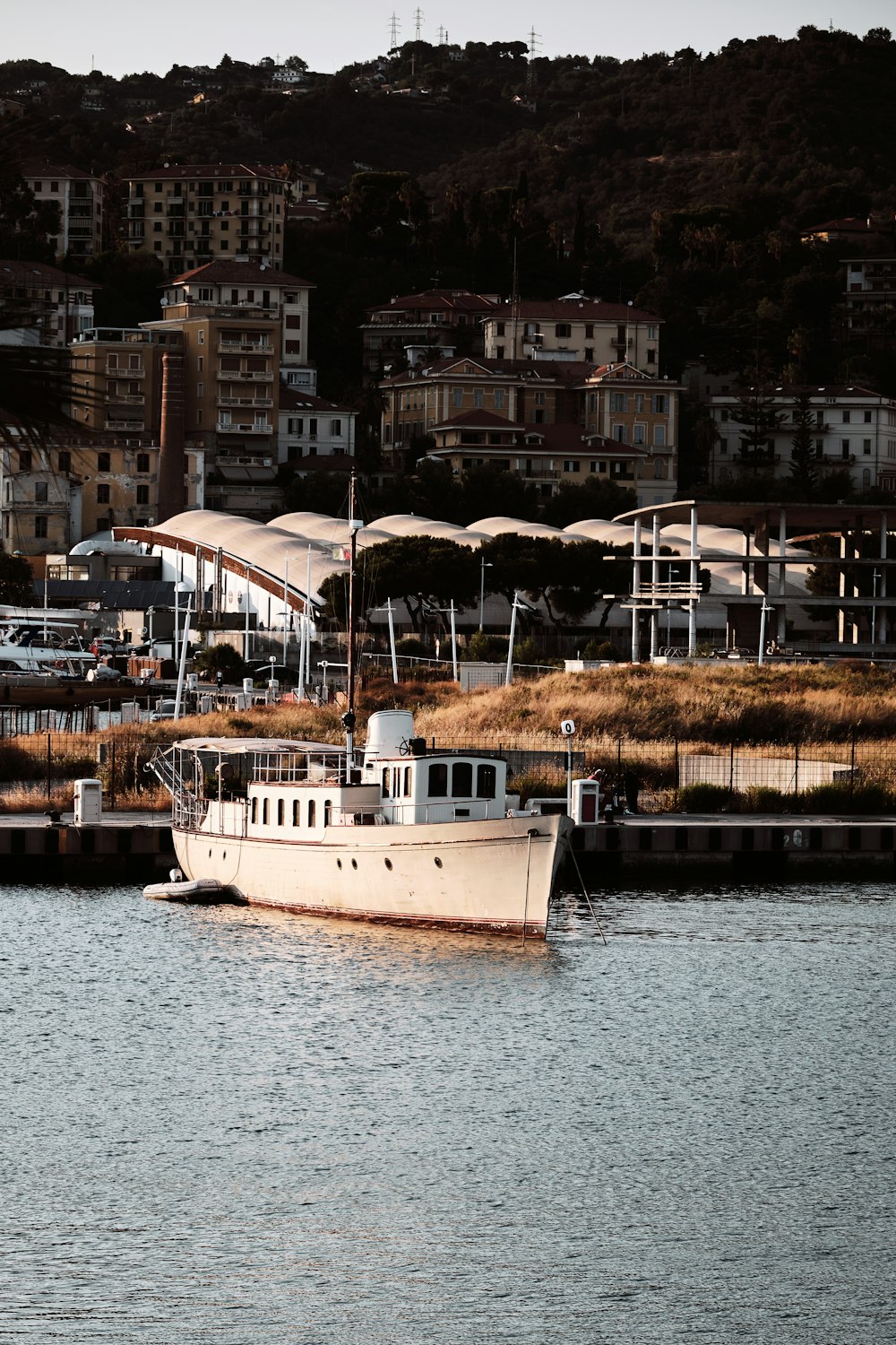 a white boat floating on top of a body of water