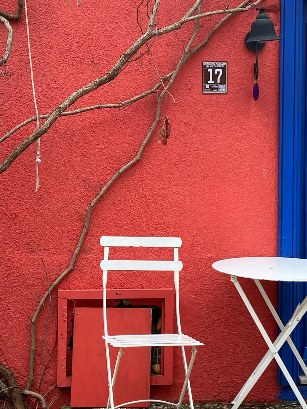 two chairs and a table in front of a red wall