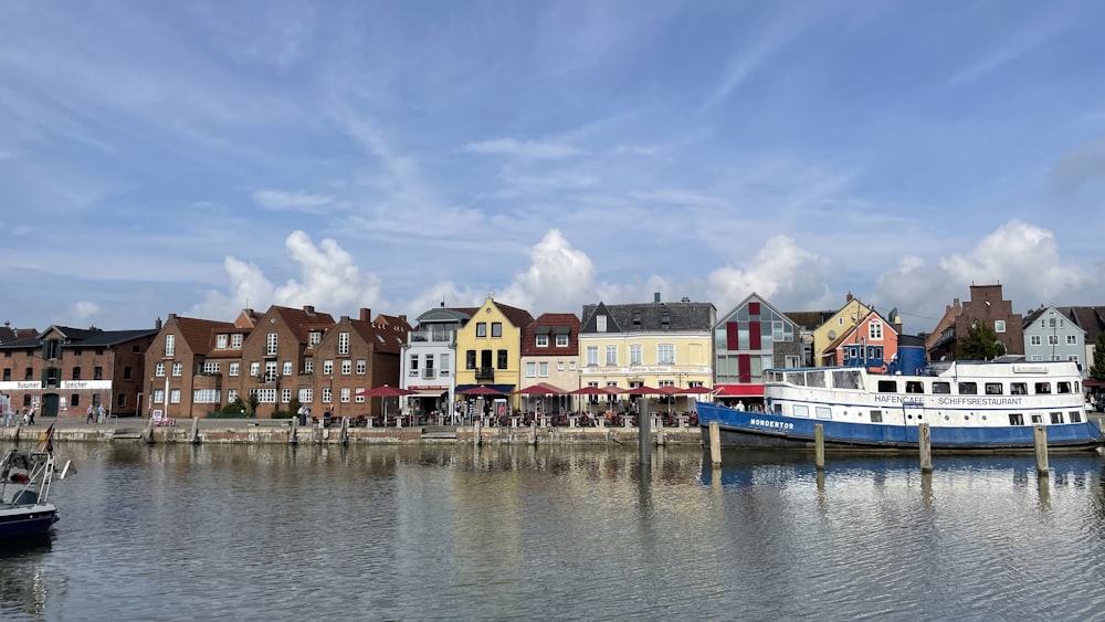 a boat docked in a harbor next to a row of houses