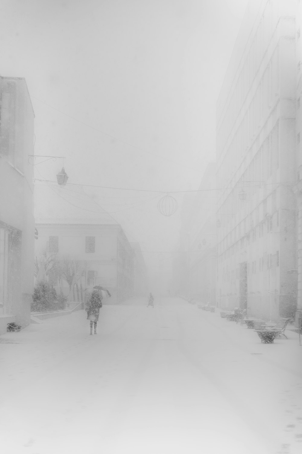 a black and white photo of people walking in the snow