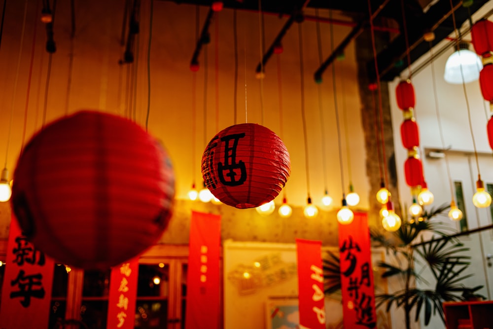 two red lanterns hanging from the ceiling of a restaurant