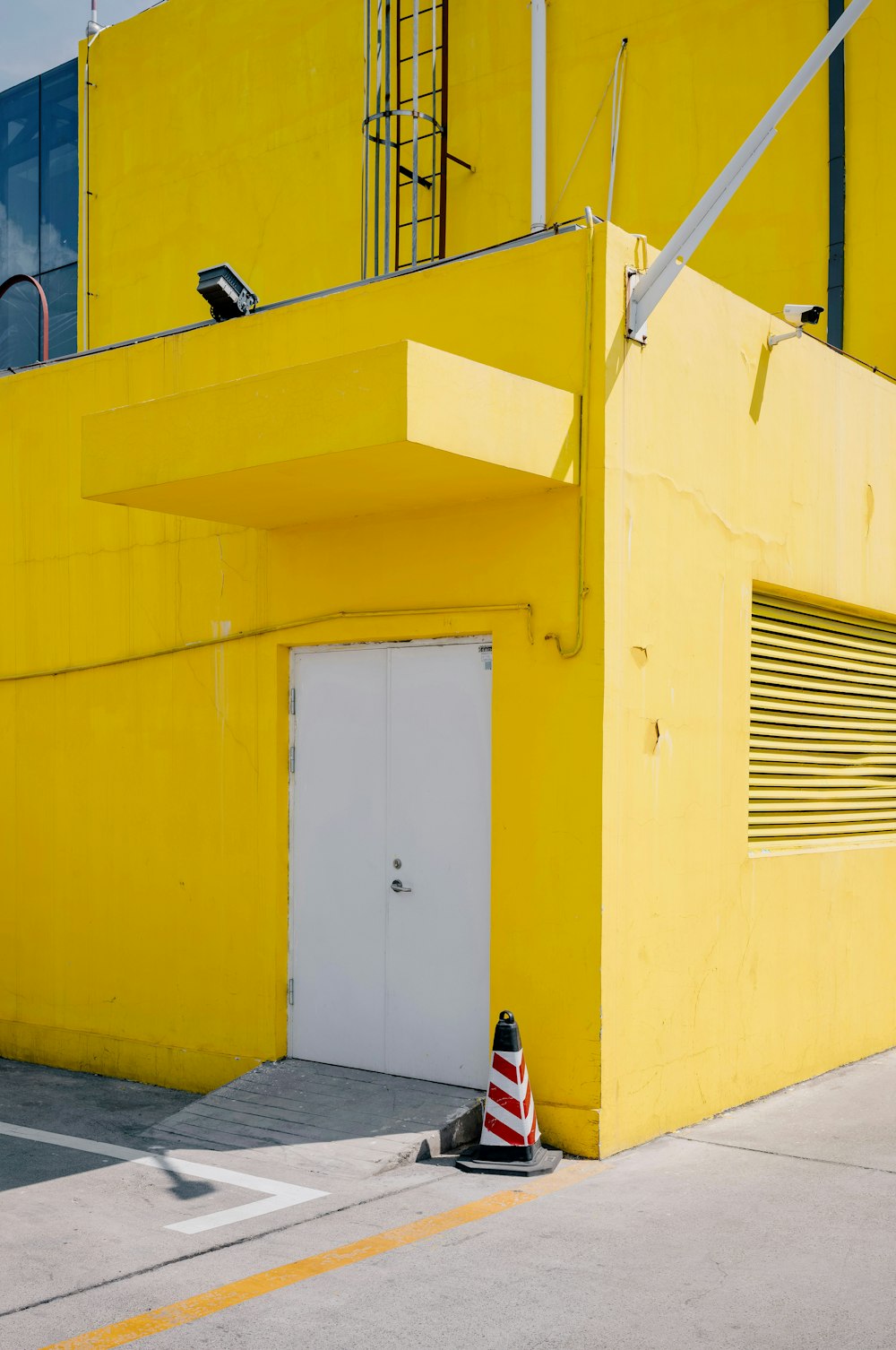 a person sitting on the ground in front of a yellow building