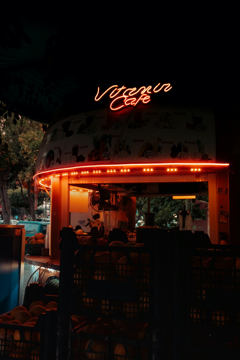 a lit up food stand at night near a pool