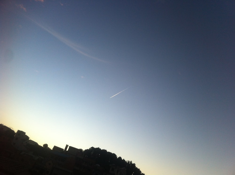 a plane flying in the sky over a city