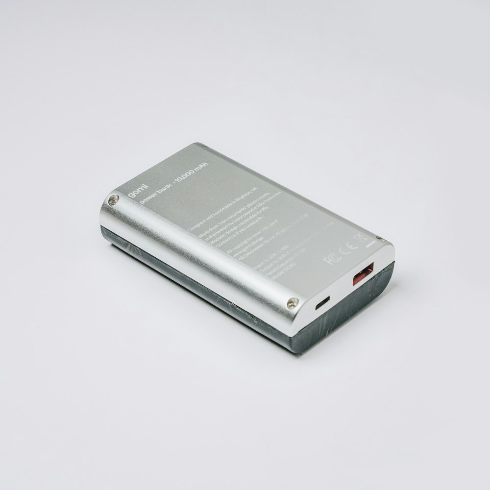 a silver electronic device sitting on top of a white table