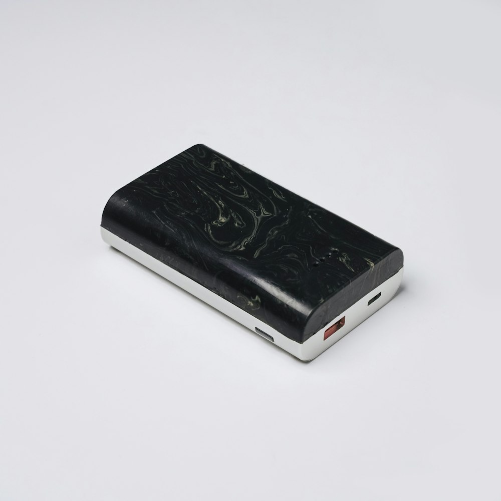 a black and silver electronic device on a white surface