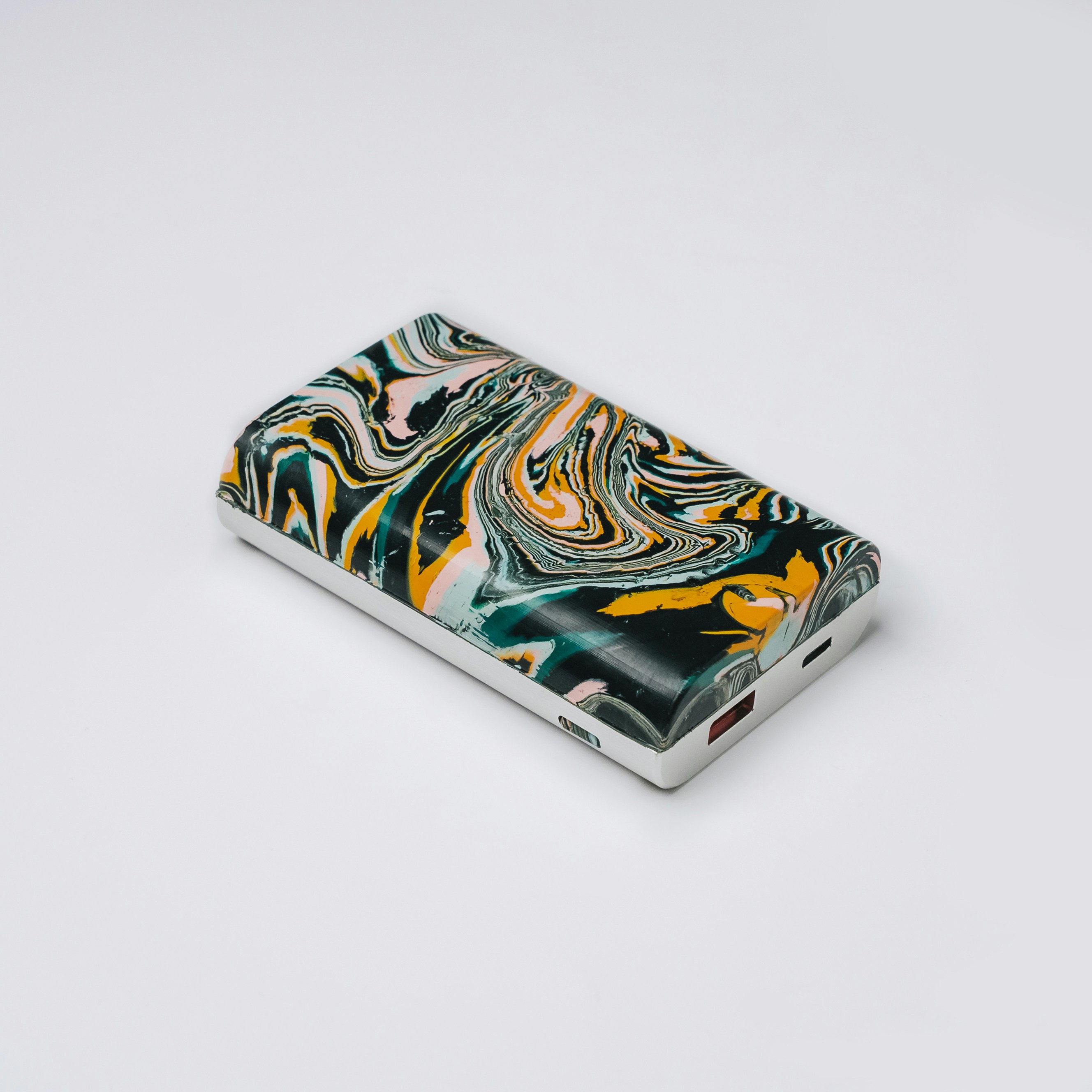 a lighter with a design on it sitting on a white surface