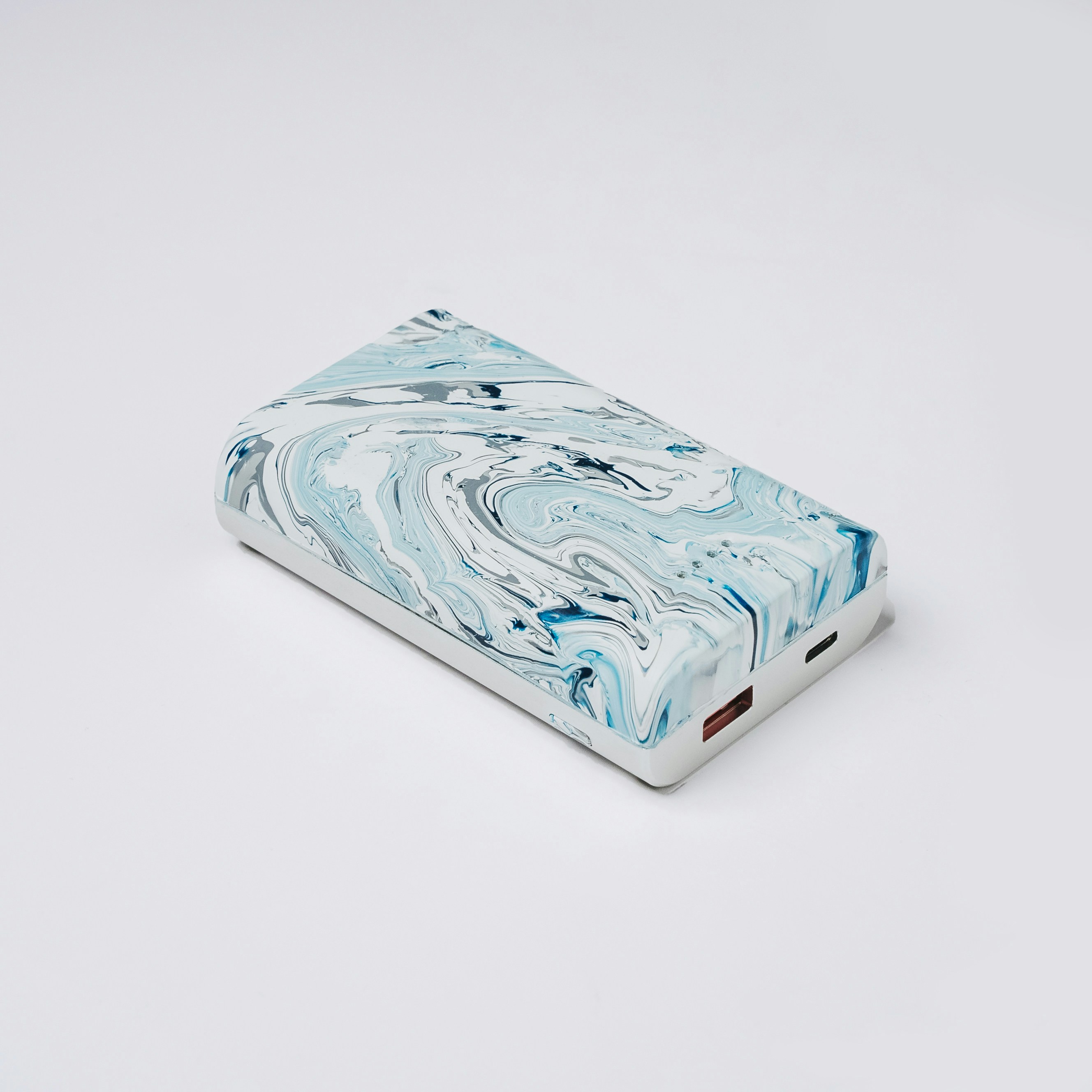 a blue and white marbled case sitting on a white surface