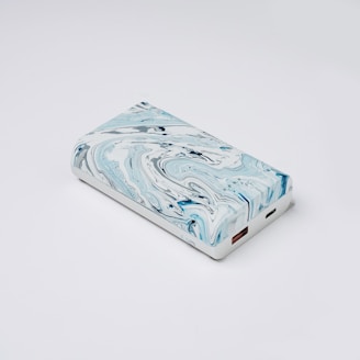 a blue and white marbled case sitting on a white surface