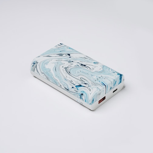 a blue and white marbled case sitting on a white surface