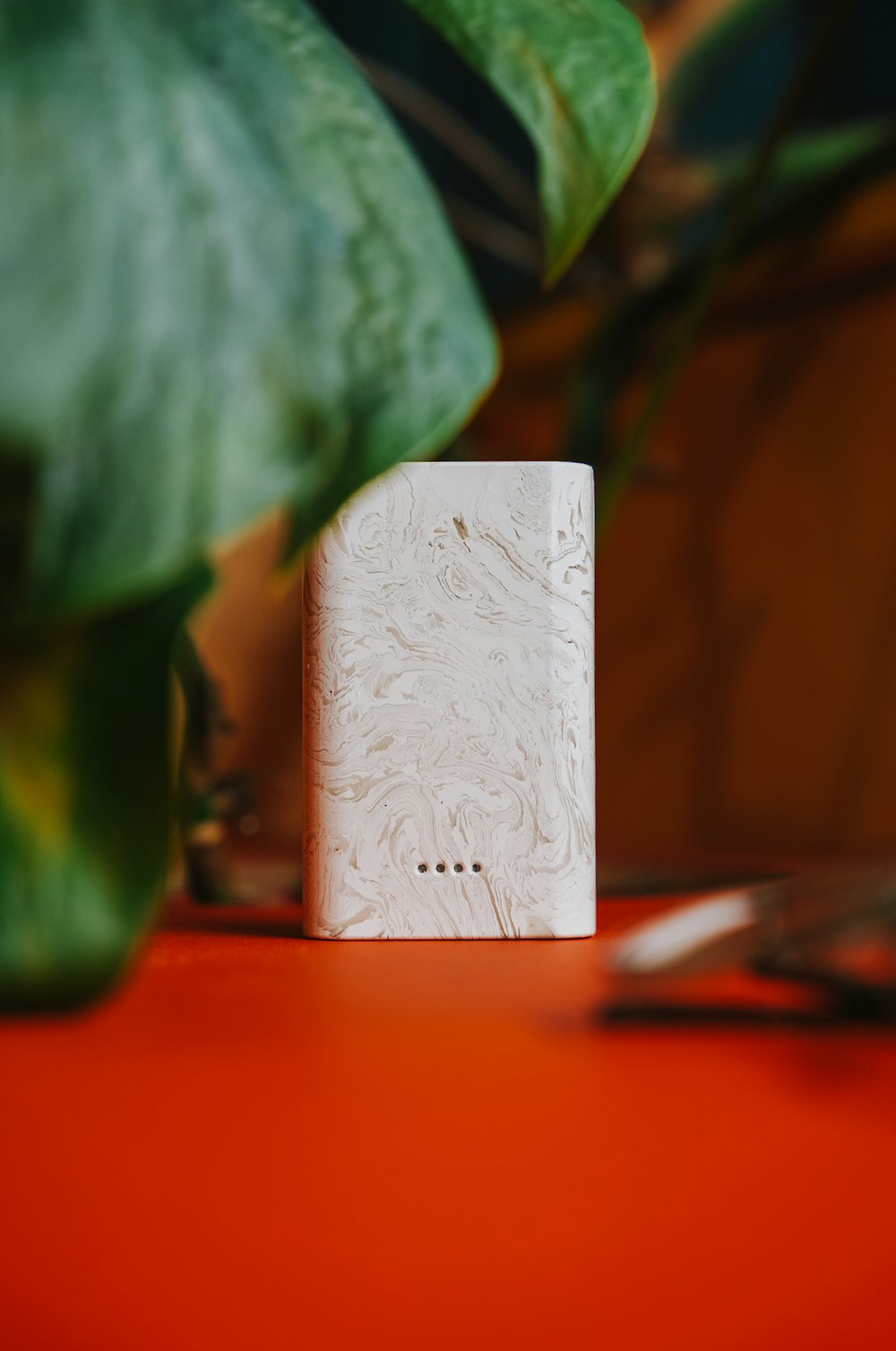 a white box sitting on top of a table next to a plant