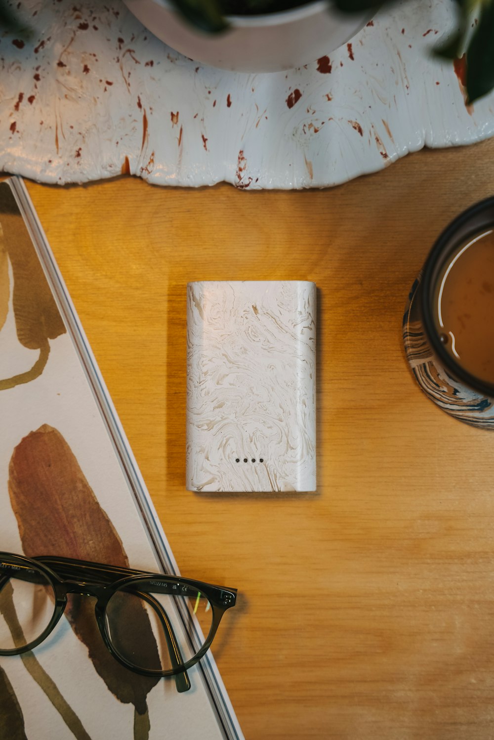 a wooden table topped with a notebook and glasses