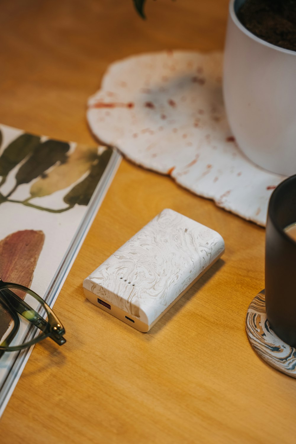 a wooden table topped with a notebook and a cup of coffee