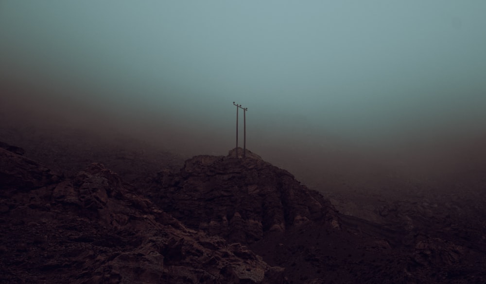 a cross on top of a mountain in the fog