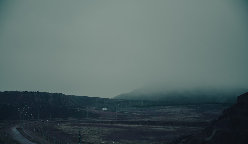 a foggy day on a highway with a mountain in the background