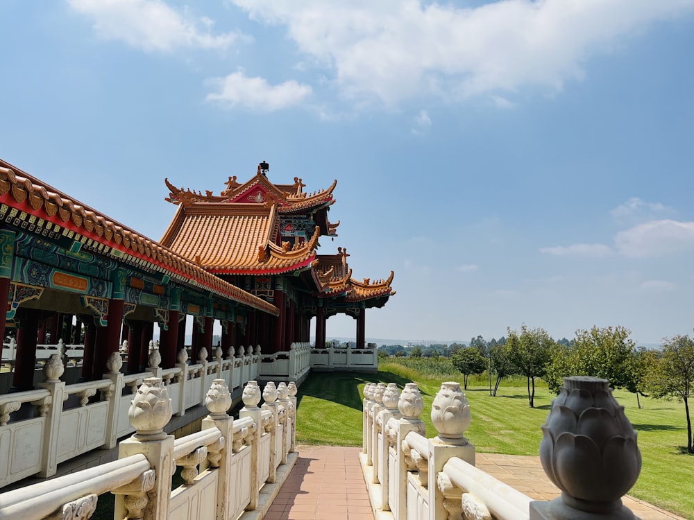 a walkway leading to a pavilion with statues on it