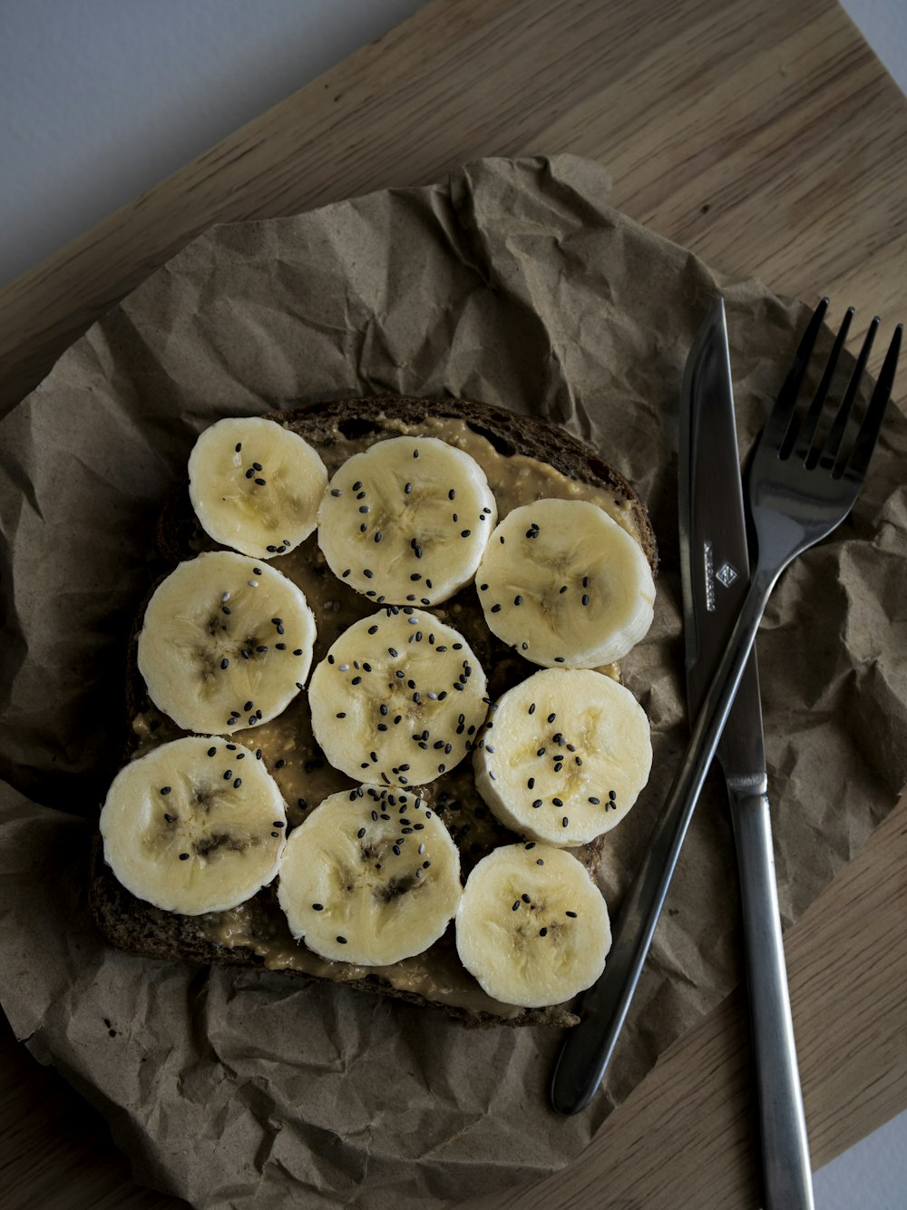 a piece of bread topped with sliced bananas and chives