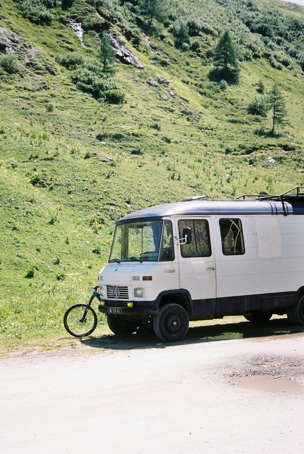 a white van parked on the side of a dirt road